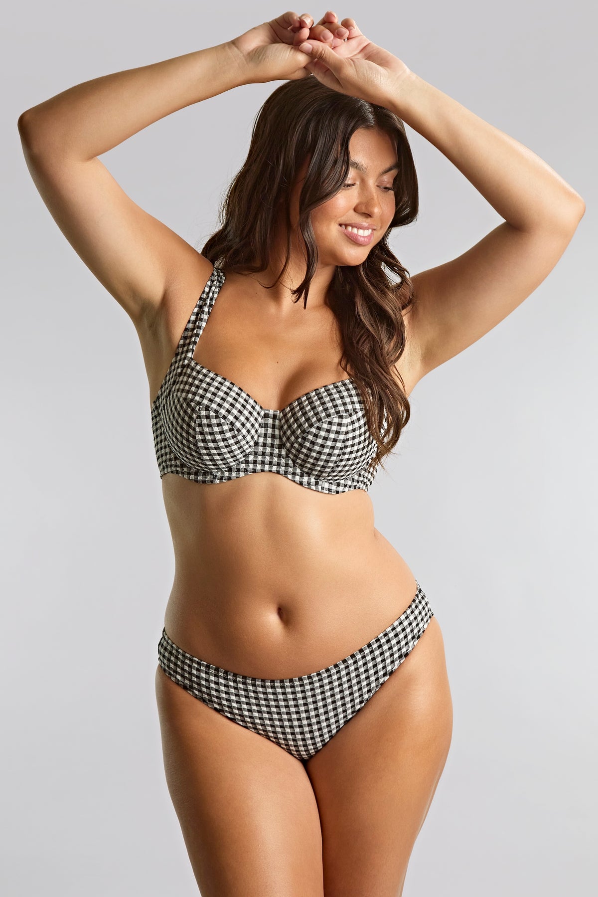 Woman wearing a black and white checkered bikini against a gray background