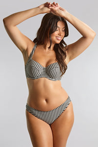 Woman wearing a black and white checkered bikini against a gray background