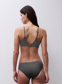 Woman wearing a gray bra and underwear set against a plain background