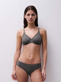 Woman wearing a gray patterned bra and underwear set against a plain background