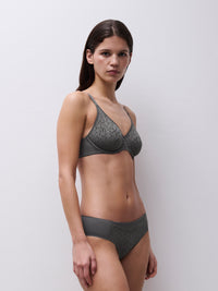 Woman wearing a gray bra and underwear set against a white background