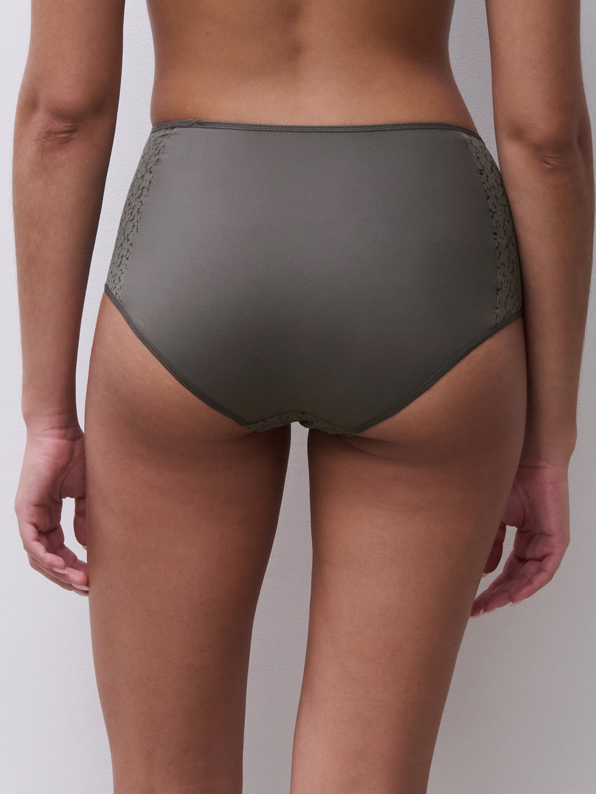 Person wearing olive green underwear on a plain background