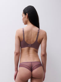 A woman shown from the back wearing a matching mauve-brown bra and panty set with sheer mesh and scalloped edges, against a plain light gray studio background.