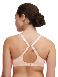 Woman wearing a beige bra with thin straps on a white background