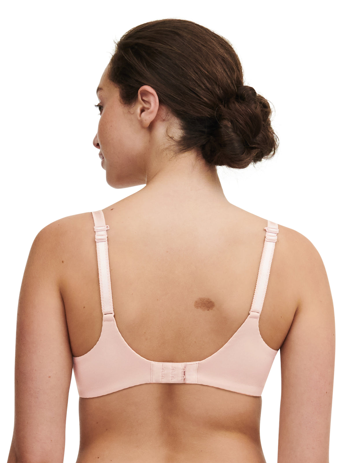 Woman wearing a light pink bra on a white background