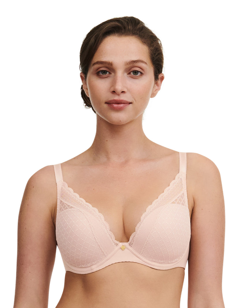 Woman wearing a light pink bra on a white background
