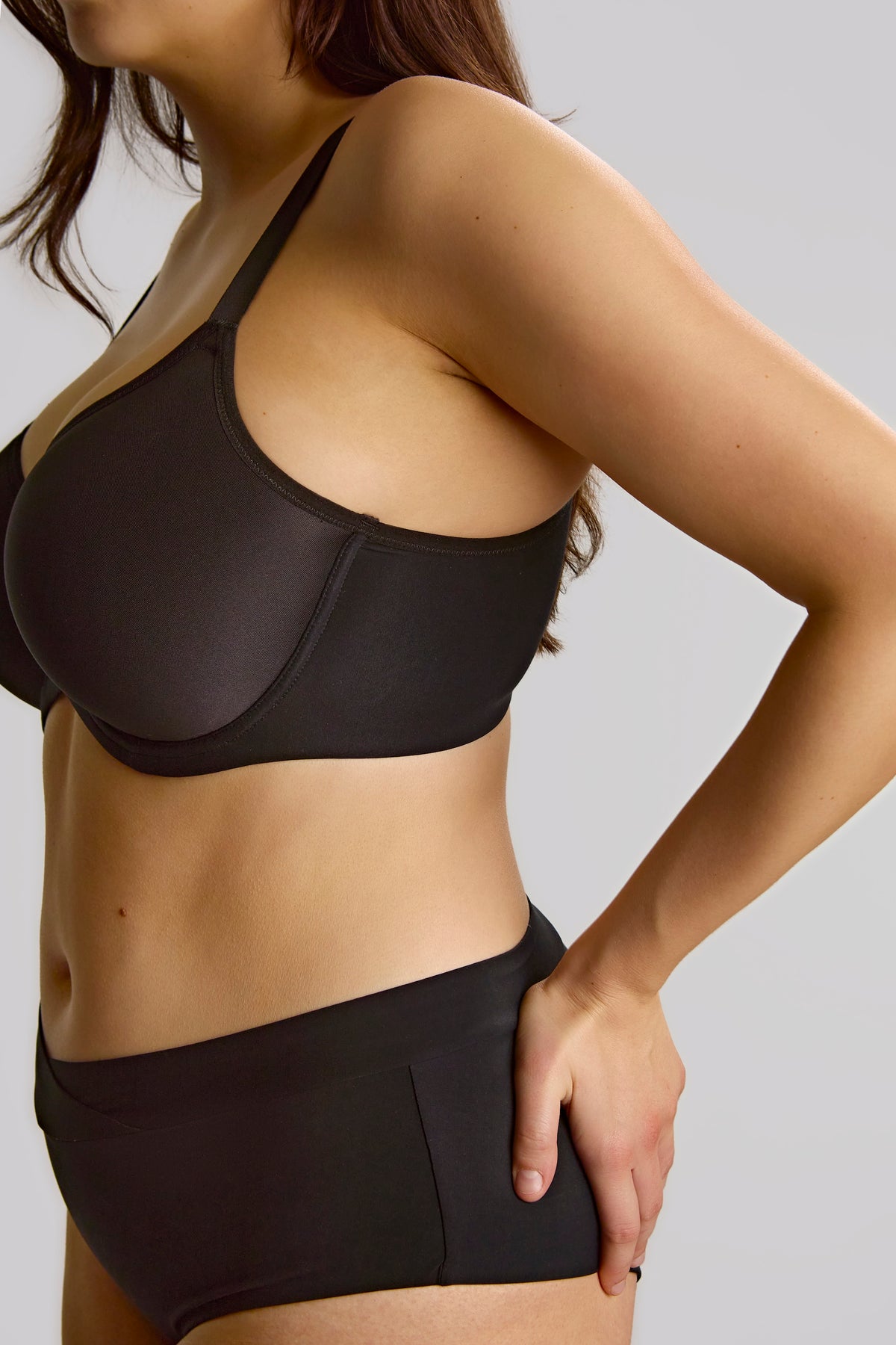 Person wearing a black bikini set on a plain background
