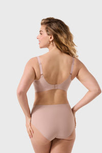 Woman wearing a beige shapewear bodysuit on a white background