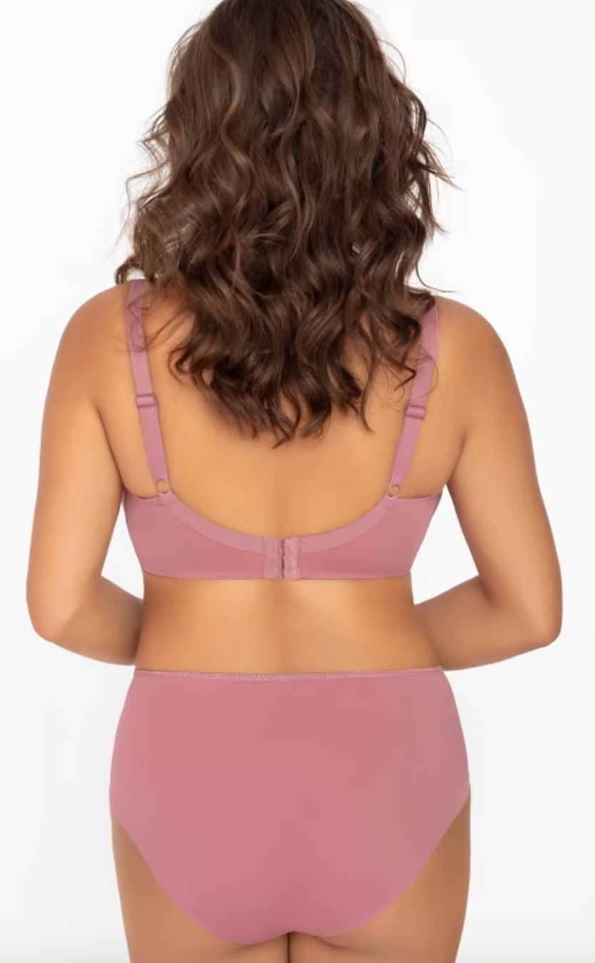 A woman shown from the back wearing a dusty pink bra and matching high-waisted briefs against a plain white studio background.