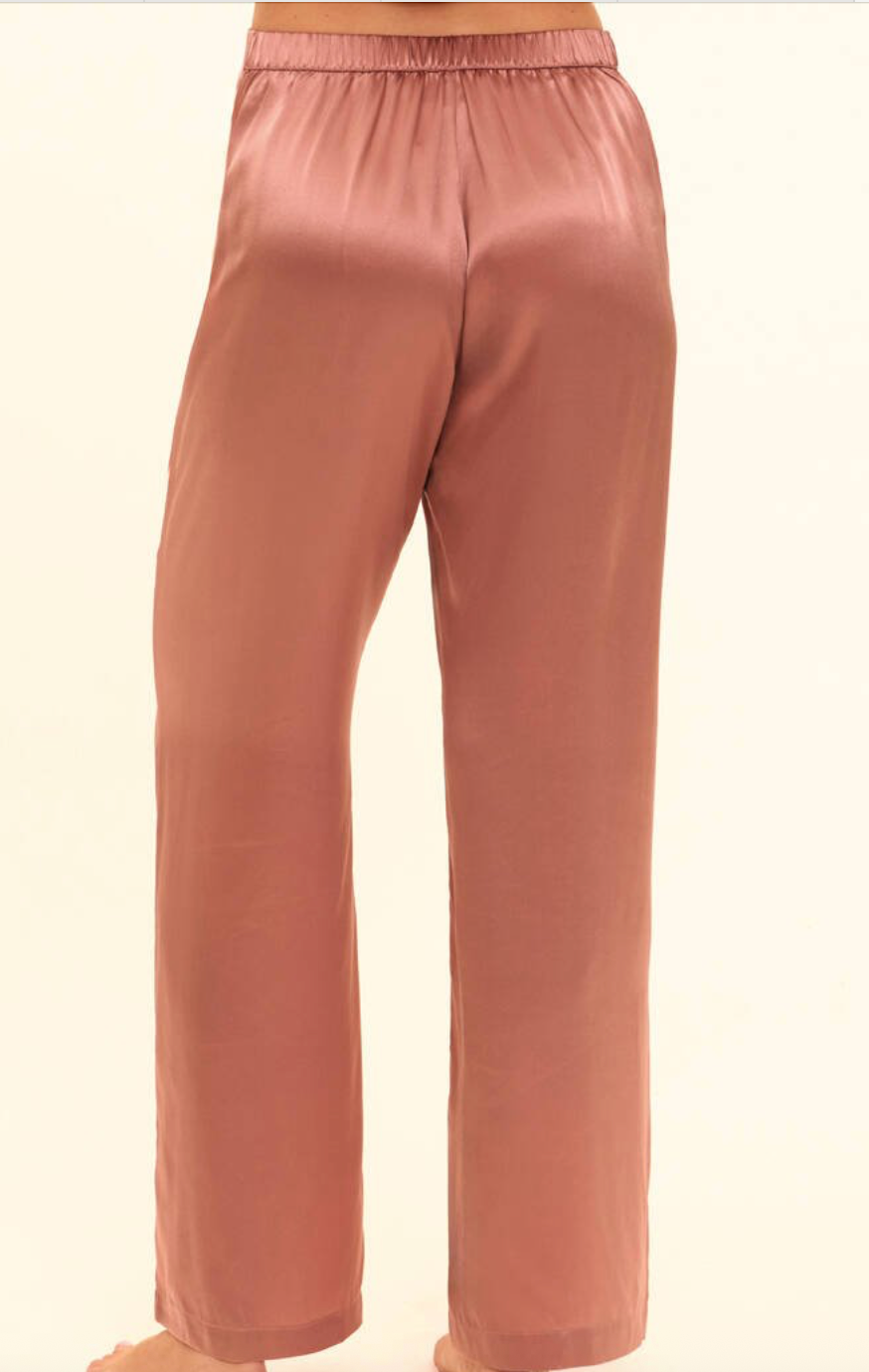 Rose gold silk pajama pants on a white background