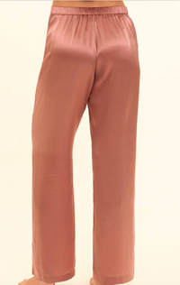 Rose gold silk pajama pants on a white background
