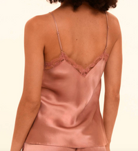 Pink silk camisole with lace trim on a plain background
