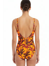 Woman wearing a one-piece swimsuit with a leaf pattern on a white background