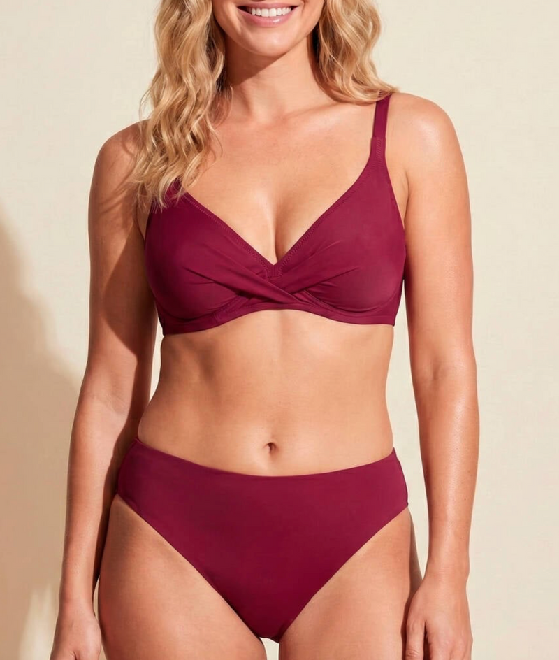 Woman wearing a burgundy bikini against a beige background