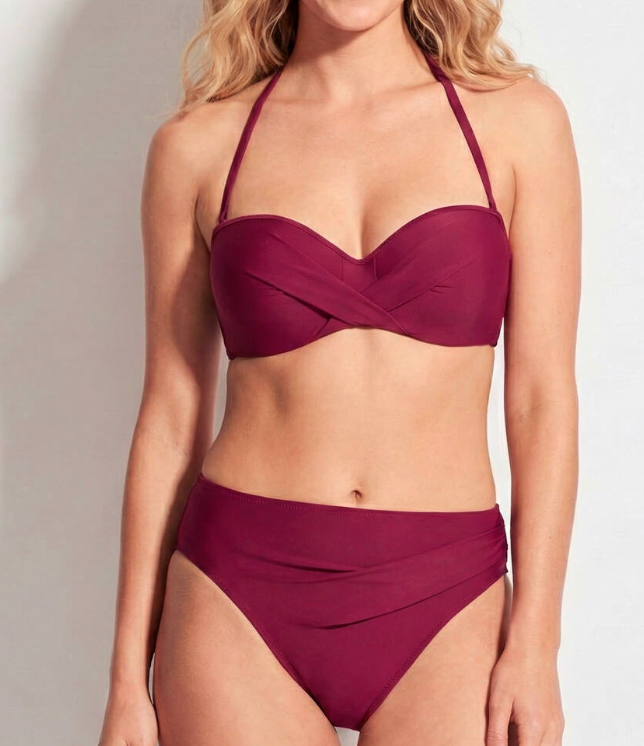 Woman wearing a burgundy bikini set against a plain background
