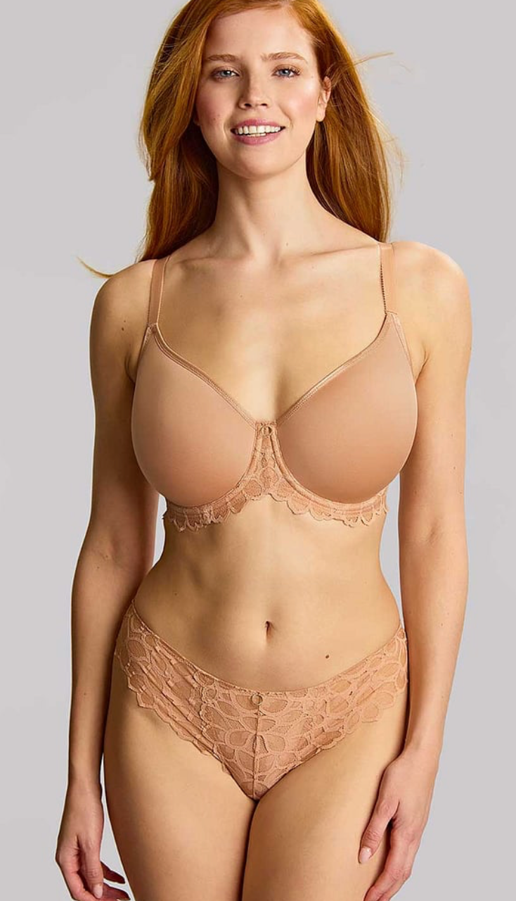 Woman wearing a beige lace lingerie set on a plain background