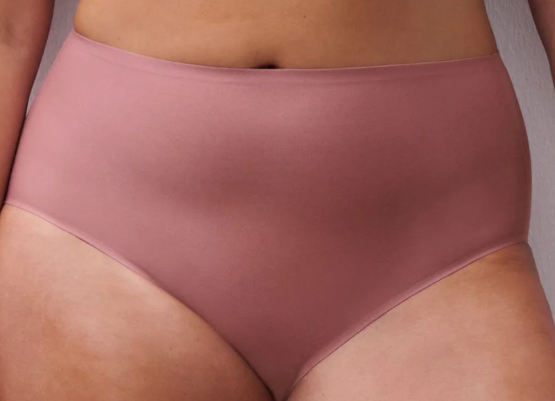 Pink high-waisted underwear worn by a person against a neutral background