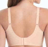 Beige bra worn by a person on a white background