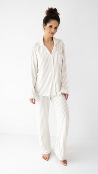 Woman wearing a white pinstripe pajama set on a white background