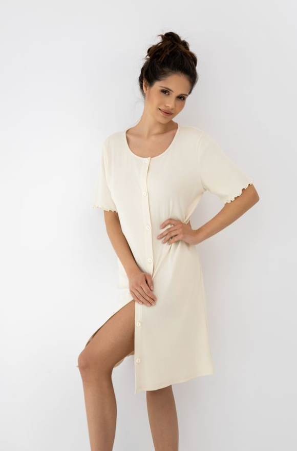 Woman wearing a soft beige night dress against a plain background