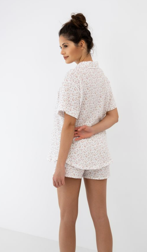 Woman wearing a white floral outfit on a white background