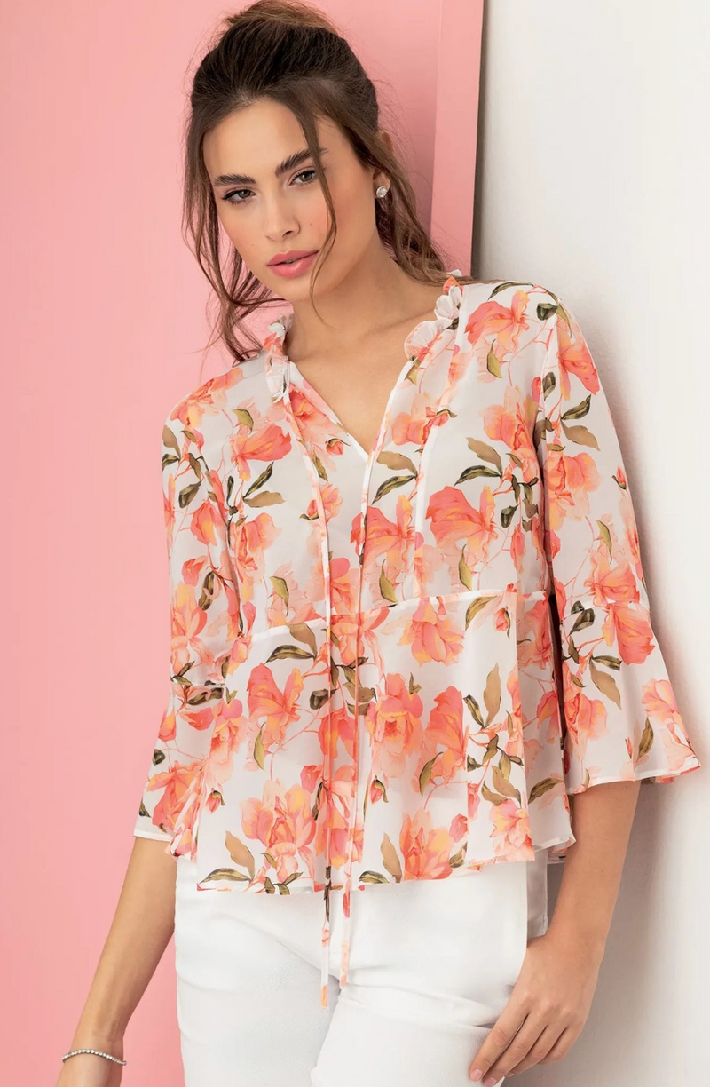 Woman wearing a floral blouse against a pink and white background