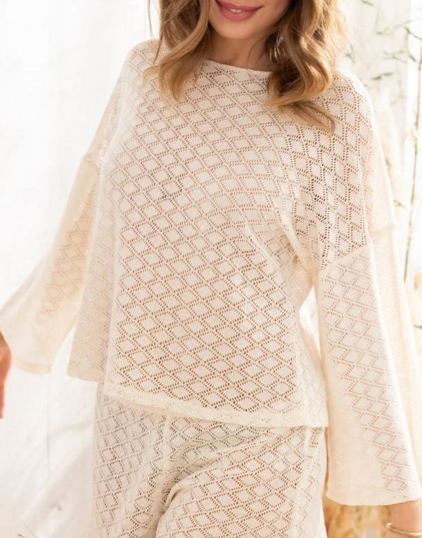 Woman wearing a beige lace outfit against a white background
