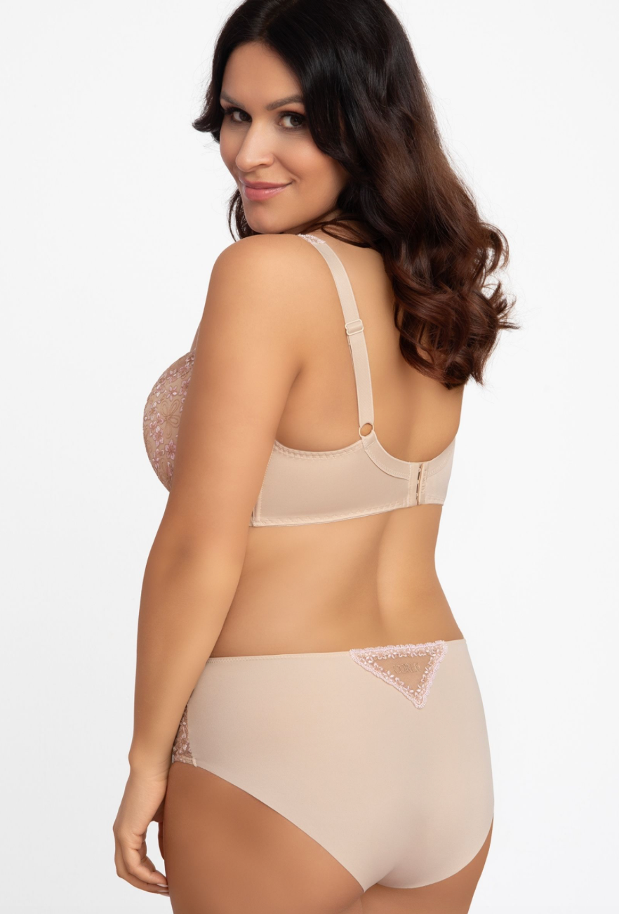 Woman wearing a beige bra and panties set on a white background