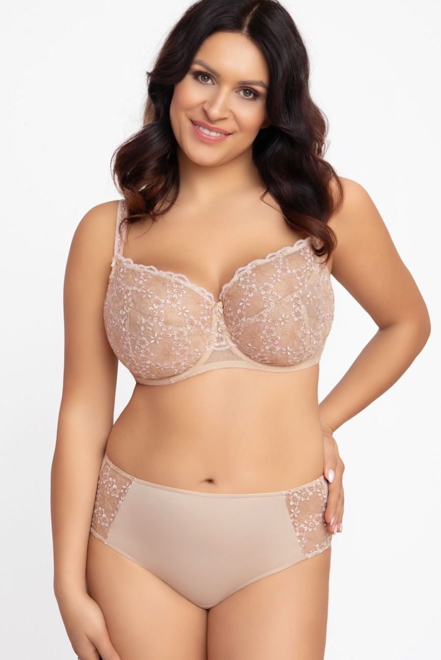 Woman wearing a beige bra and panties set on a white background