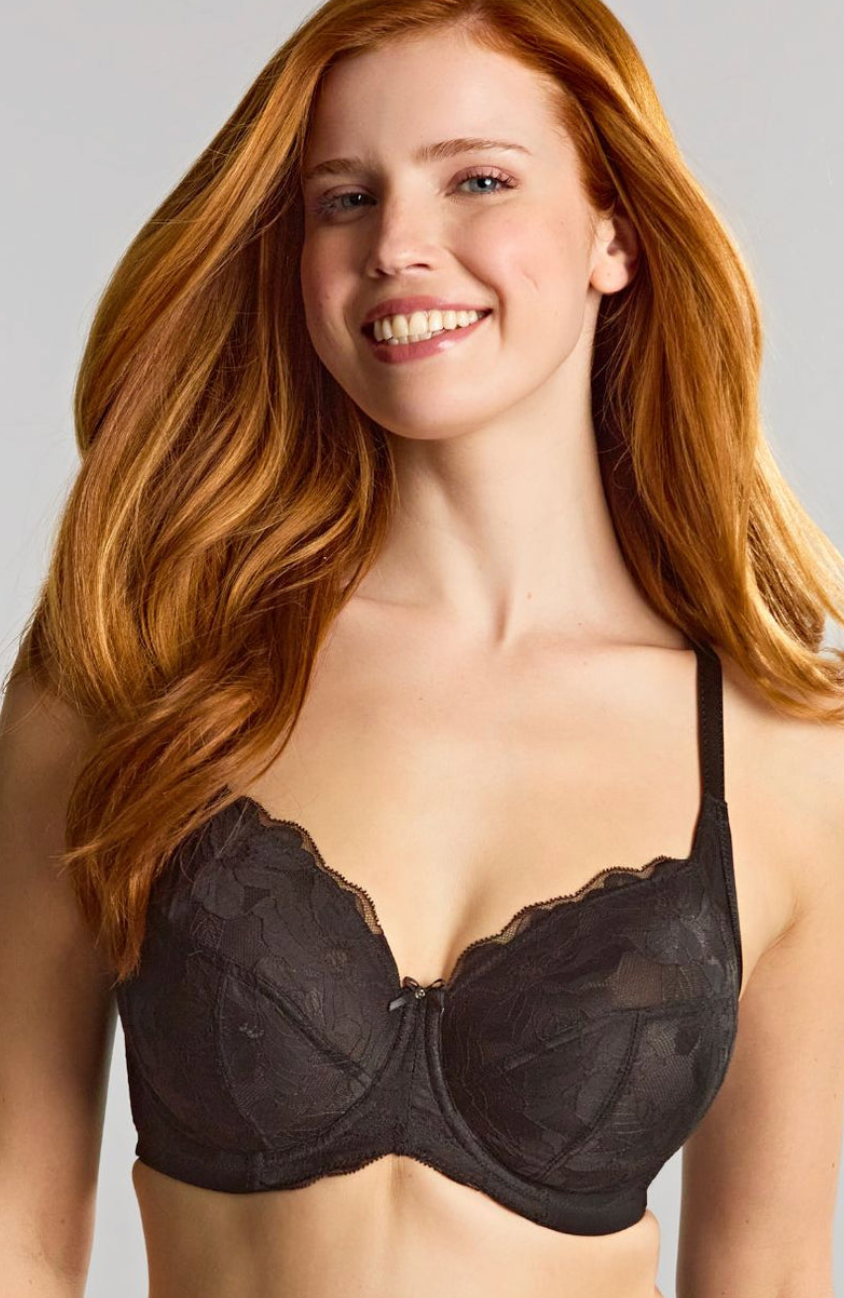 Woman wearing a black bra against a neutral background