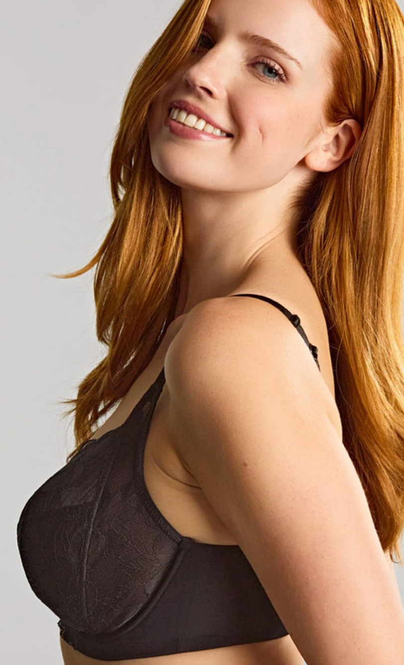 Woman wearing a black bra against a plain background