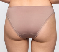 Rear view of a person wearing a sheer, nude-toned high-waisted brief or shapewear bottom against a light gray studio background.