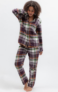A woman modeling a two-piece plaid pajama set with a long-sleeve button-up shirt and matching pants. The pajamas feature a multicolor tartan pattern with purple, green, orange, and white stripes, photographed against a clean white studio background.