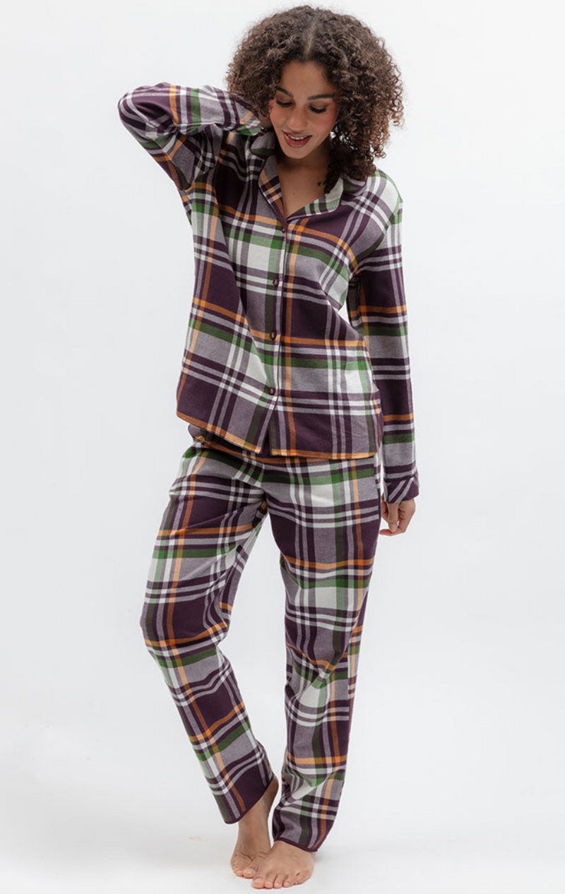 A woman modeling a two-piece plaid pajama set with a long-sleeve button-up shirt and matching pants. The pajamas feature a multicolor tartan pattern with purple, green, orange, and white stripes, photographed against a clean white studio background.