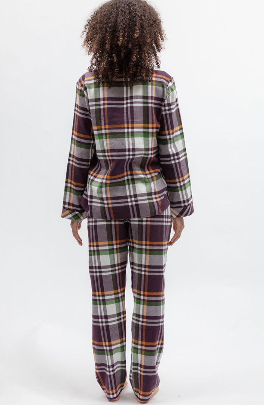 A model viewed from the back wearing a matching plaid pajama set with a long-sleeve top and pants in purple, green, orange, and white.