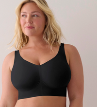 A blonde woman wearing a black wireless bra, shown from the chest up against a plain light background.