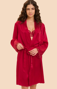 A woman modeling a long-sleeve silk red robe with a tie waist, shown against a plain beige studio background.