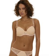 Woman wearing a beige bra and panties set on a white background