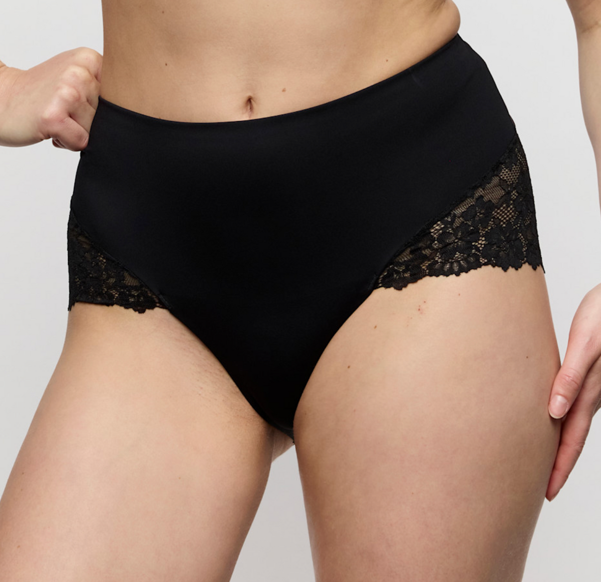 Black lace-trimmed underwear on a plain background