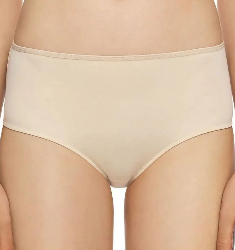 A close-up of a model wearing high-waisted, seamless underwear in a light beige or nude color, shown from the waist to the upper thighs against a plain white background.