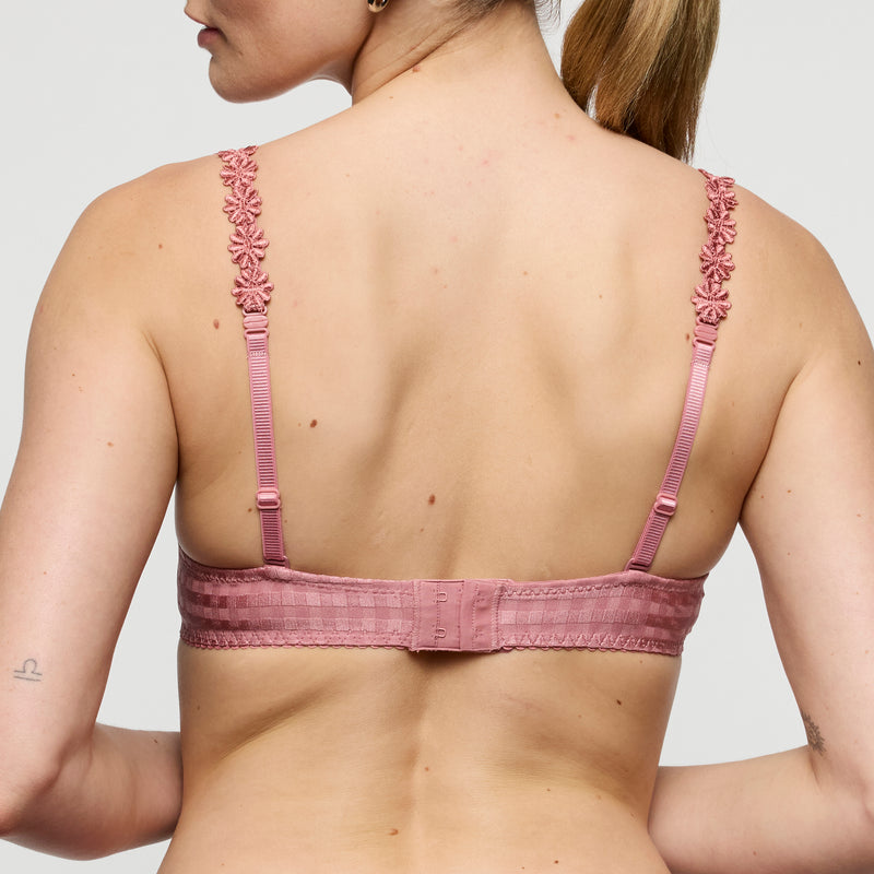 Pink bra with floral straps worn by a model on a plain background