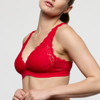 Red lace bra worn by a model on a light gray background