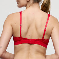 Red bra worn by a person on a plain background