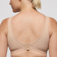 Beige wireless bra worn by a person on a plain background