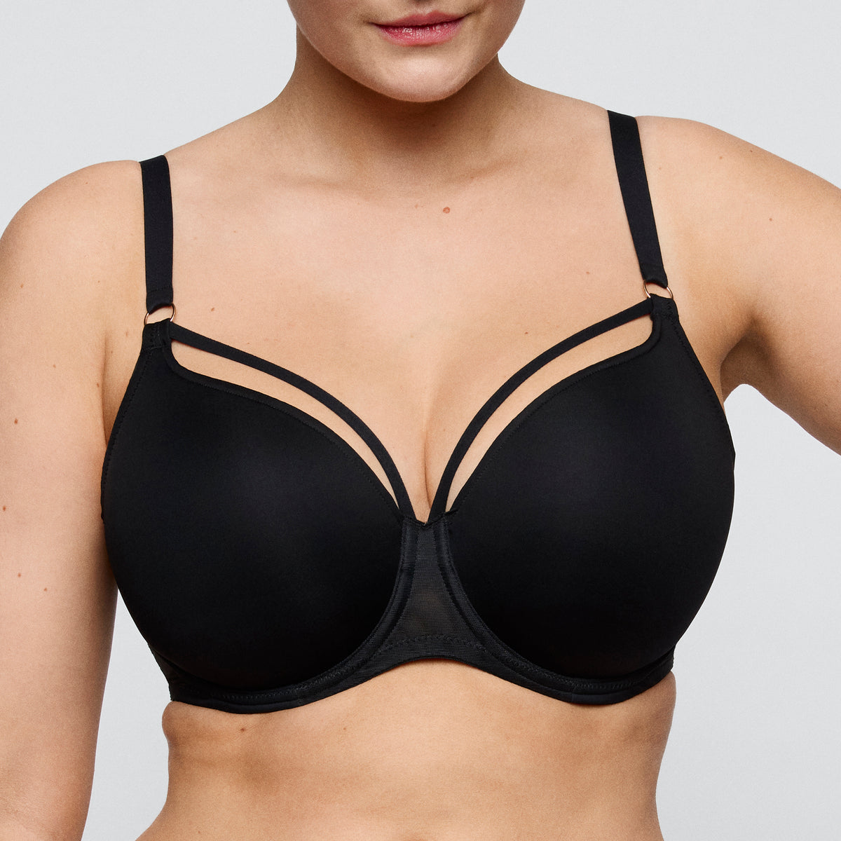 Black bra worn by a person on a plain background