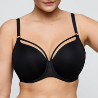 Black bra worn by a person on a plain background