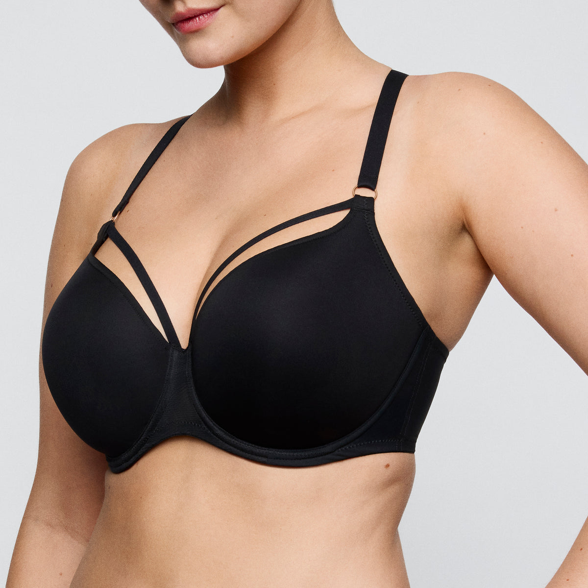 Black bra worn by a model on a plain background