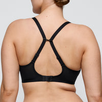 Black bra worn by a person on a plain background