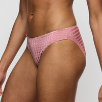 Person wearing a pink textured bikini bottom on a light gray background