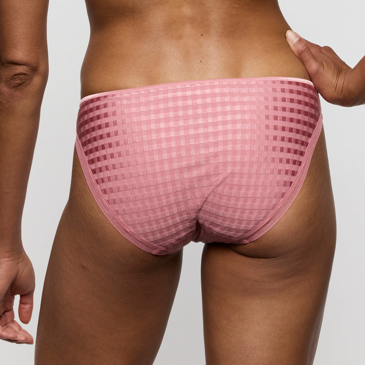 Person wearing a pink checkered underwear on a plain background